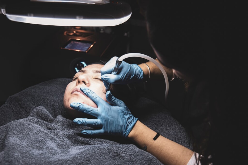 Aesthetic clinician performing a facial device-based skin treatment procedure on a patient, representing the combination of microneedling and PRP therapy