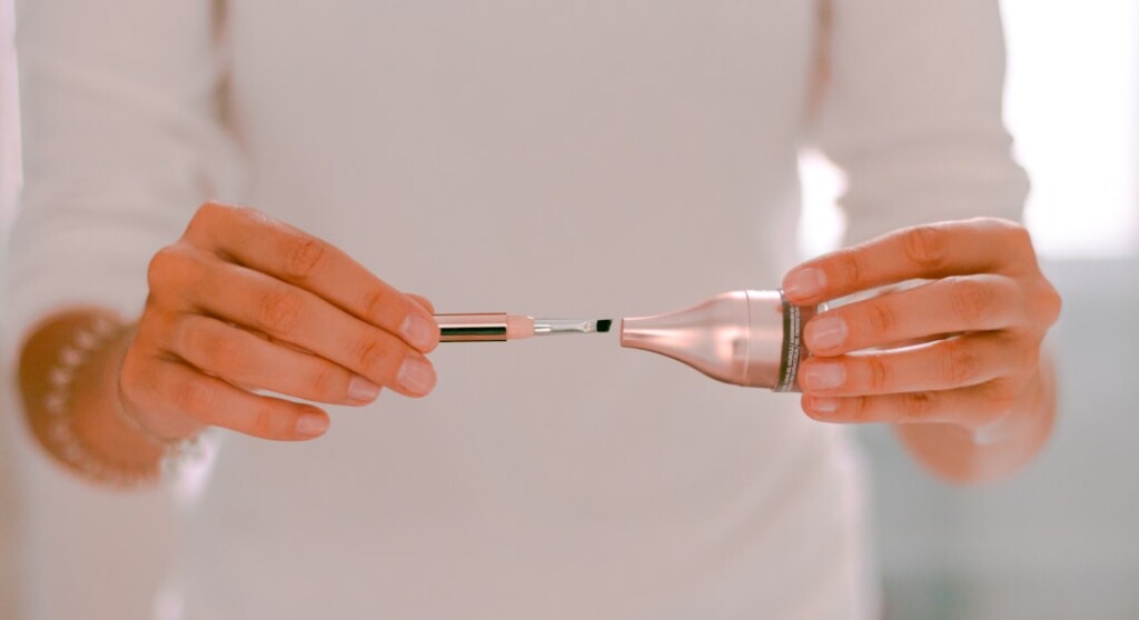 Personne tenant un stylo de micro-aiguillage, illustrant l'outil utilisé dans le cadre de la thérapie par induction de collagène pour le rajeunissement de la peau